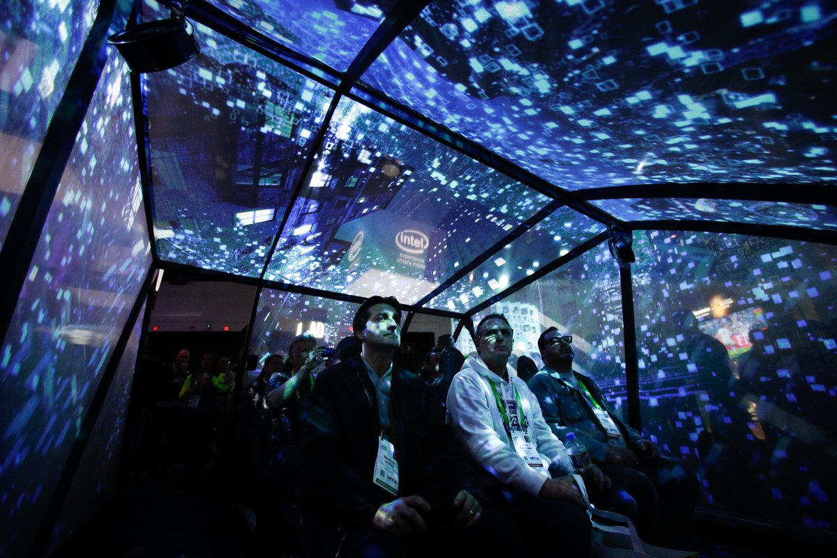 Attendees sit in an autonomous driving experience tent at the Intel CES booth.