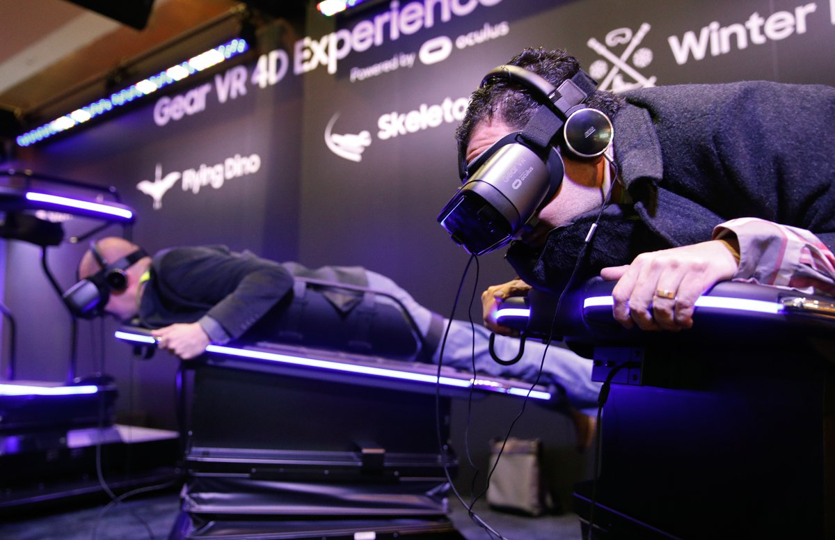 People experience a ride with the Samsung Gear VR virtual reality goggles at the Samsung booth.